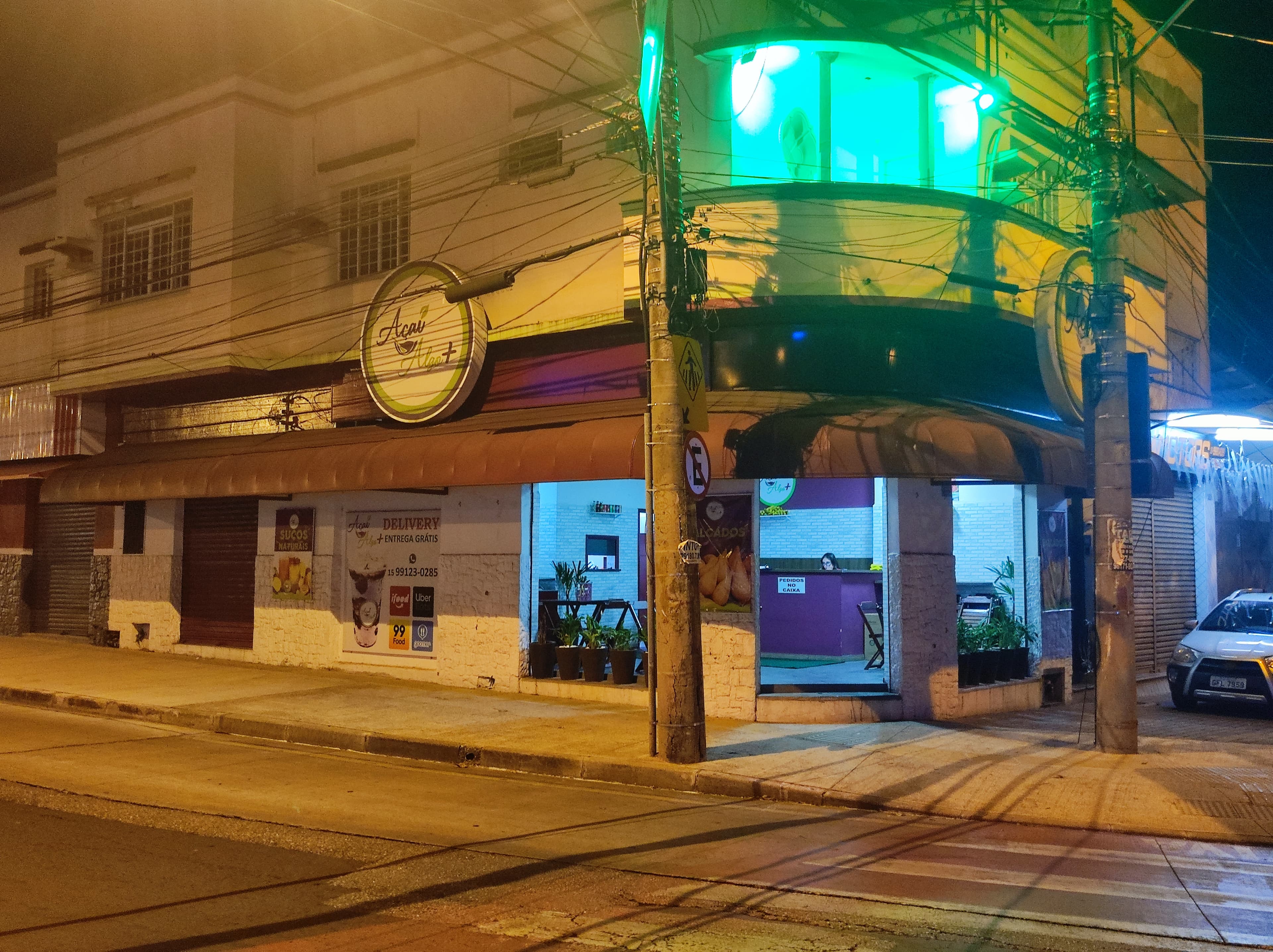 Fachada da loja Açaí Algo Mais em Sorocaba à noite, com placa iluminada em verde neon